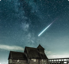 A plush toy robot sitting against a yellow wall